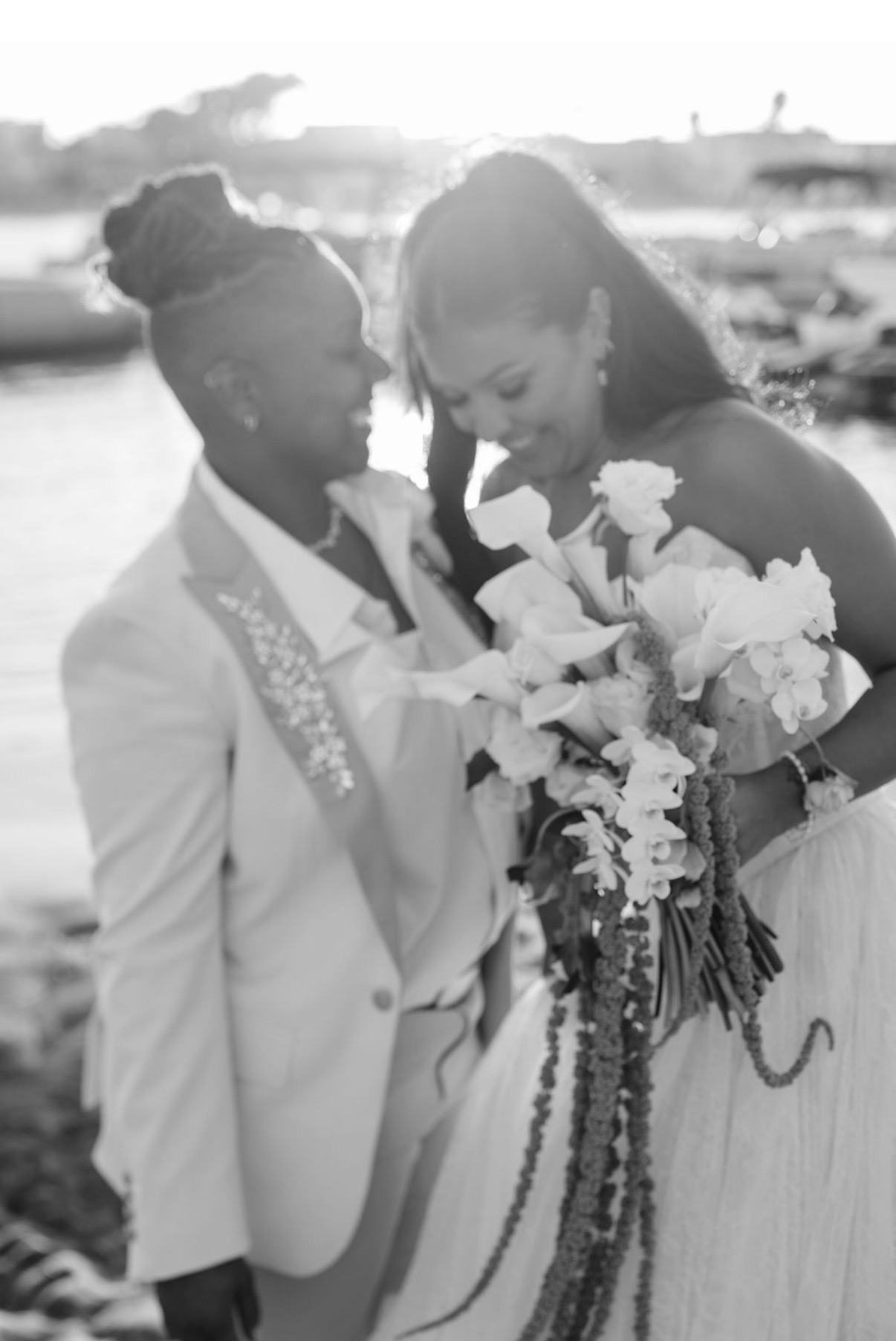 Black and white portrait of newlyweds sharing a quiet moment by the waterfront