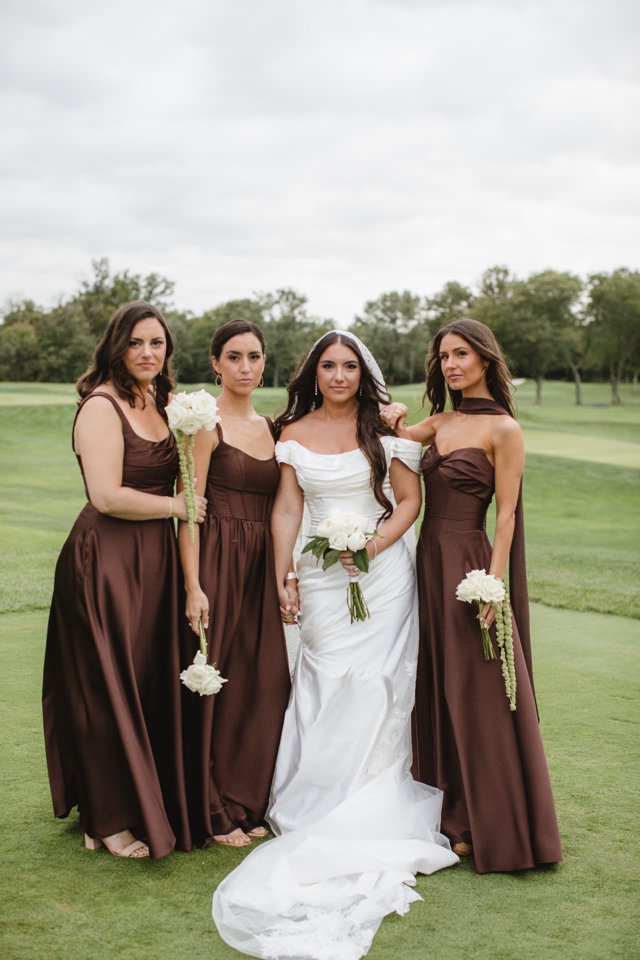 Bride with her bridesmaids in brown dresses on the golf course