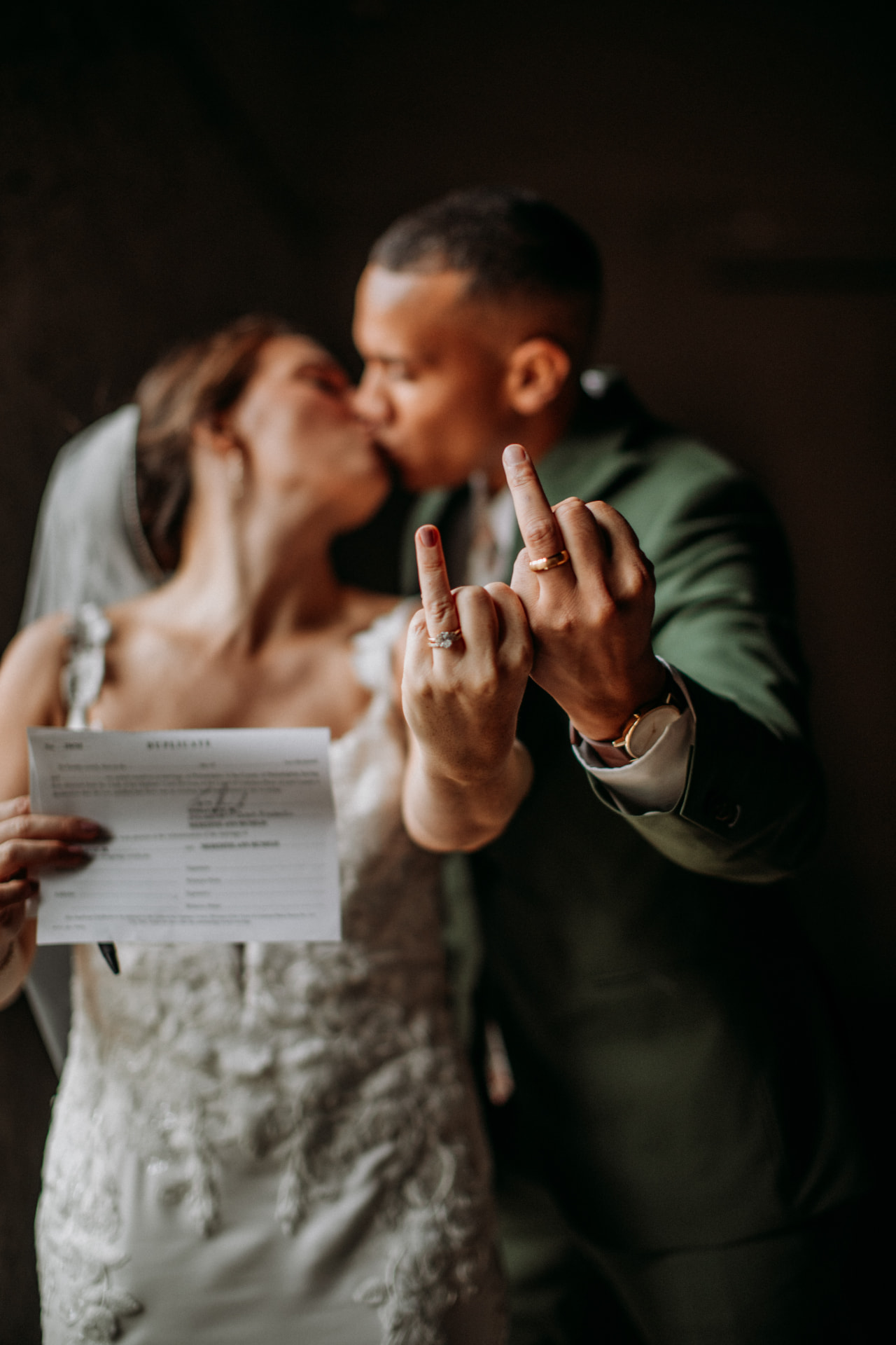 Newlyweds kissing while showing off their wedding rings