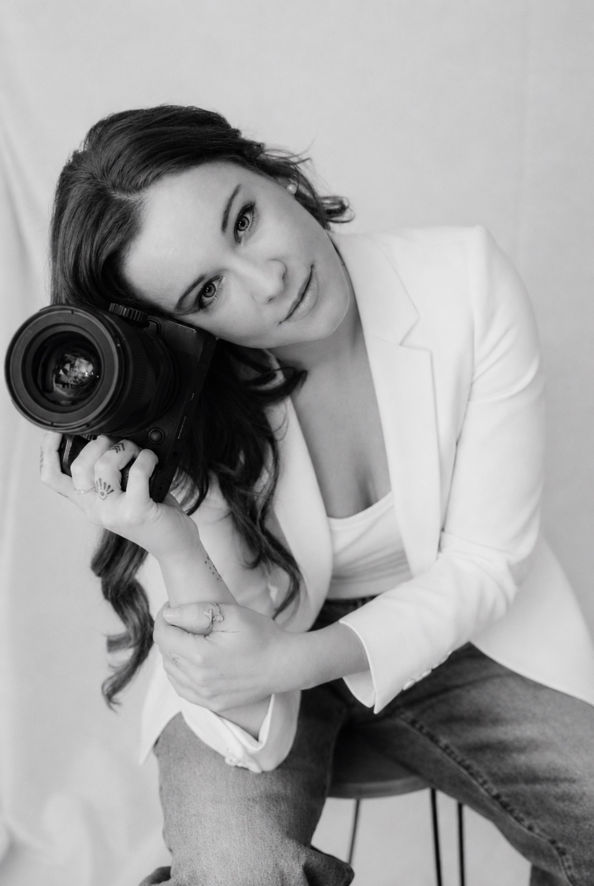 Rae, owner of Rae Photo Film, holding a camera to her cheek